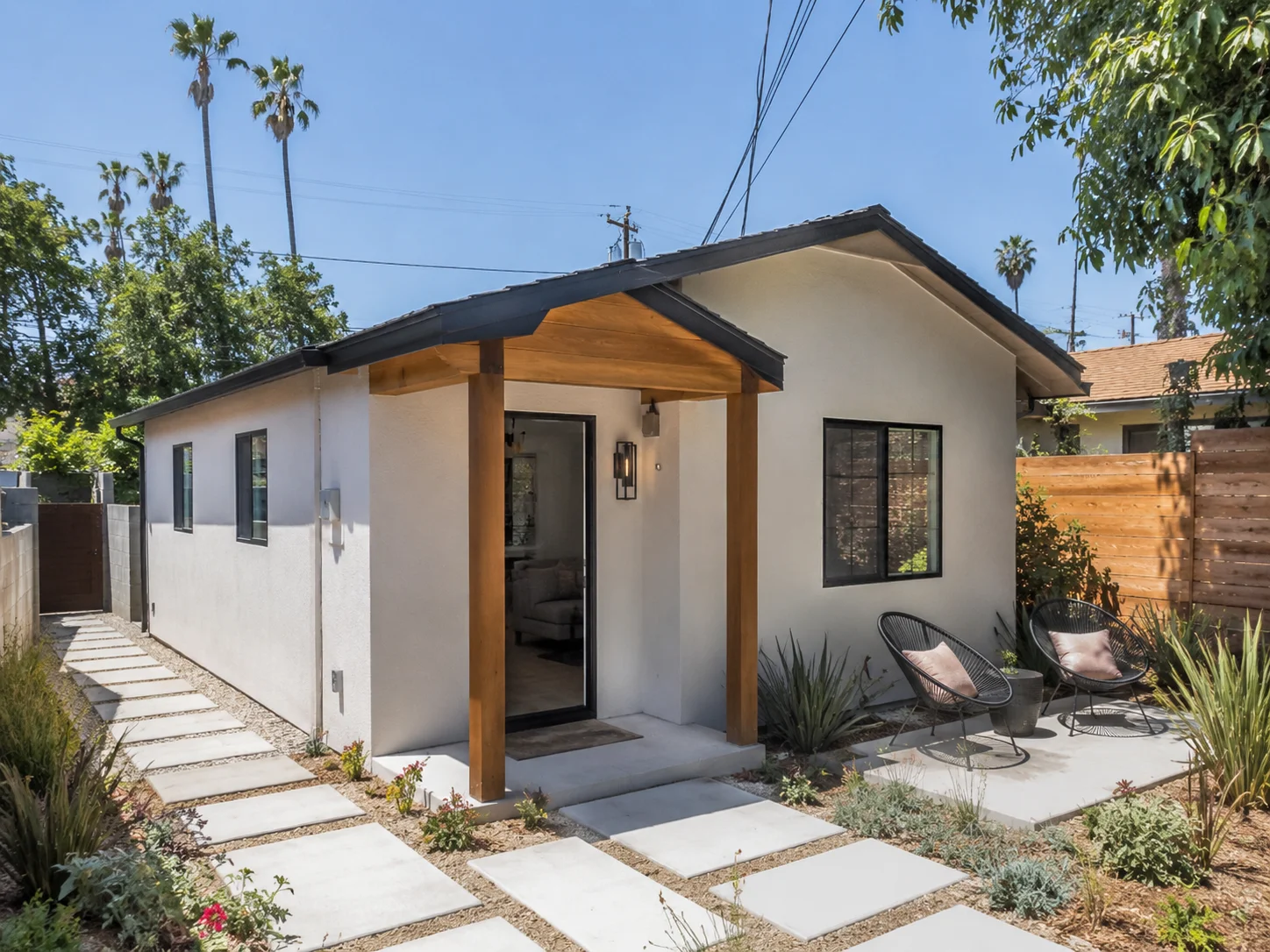 Los Angeles backyard detached ADU with concrete path and outdoor seating \u2014 a legally permitted unit ready for long-term rental
